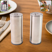 Stainless steel salt and pepper shaker set with brushed finish on kitchen table
