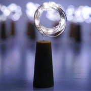 An illuminated wine bottle cork string light creating a warm ambiance on a wooden surface.