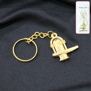Golden Shivling metal keychain displayed on white background symbolizing spiritual devotion