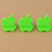 Assorted color apple-shaped mobile phone stands displayed together