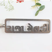 Gujarati text metal keychain featuring devotional design