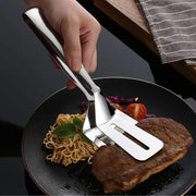 Ergonomic stainless steel kitchen tong holding grilled vegetables.