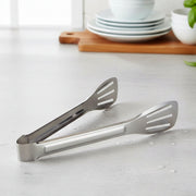 Serving tongs laid next to plates, ideal for serving snacks and salads
