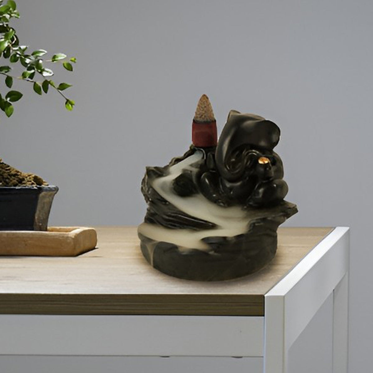 Backflow Incense Burner stand featuring Lord Ganesha, creating a cascading smoke effect.