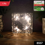 Several ice cube solar lights illuminating a garden pathway at night.