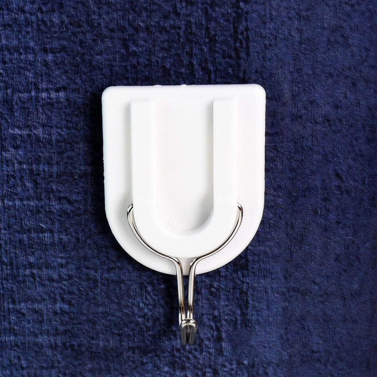 A small adhesive hook in a hallway, perfect for hanging keys and other small items.