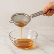 Kitchen strainer filtering liquids during cooking process