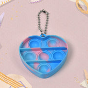 A hand holding a mini fidget keychain, highlighting its small size and easy grip for on-the-go stress relief.