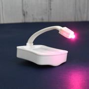 Hand holding the battery-operated LED toilet light, highlighting its portable design.
