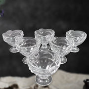 Three glass dessert bowls displayed from an angle, emphasizing their clear finish.