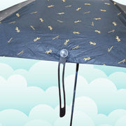A close-up of the black umbrella canopy shows the gold musical note pattern and the handle's attachment point.