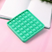 Silicone Pop It toy being held in hand for scale