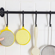 Close-up image of double-sided kitchen cleaning dishwashing sponge brush