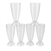 Transparent plastic milkshake glasses neatly arranged on a dining table