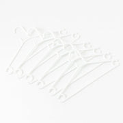 Stack of 6 white plastic clothes hangers ready for use
