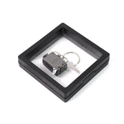Nail clipper keychain attached to travel essentials with suitcase shape