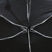 The interior of a black umbrella reveals its silver metal spokes and central mechanism.