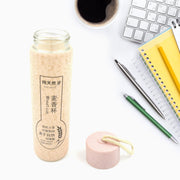 FERVENT glass water bottle placed on a wooden table in a contemporary setting.