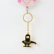 Golden Shivling keychain displayed on white surface showing metal craftsmanship
