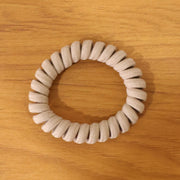 Multiple spiral coil hair bands in assorted shades, offering versatile styling.