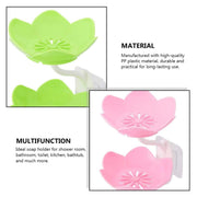 Flower-shaped self-draining soap dish displayed on a countertop next to a sink.