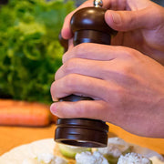 Top view of the adjustable ceramic grinder on the wooden pepper mill, showing the control nut.