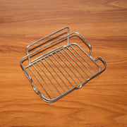 Stainless steel soap holder placed beside kitchen sink area for soap storage