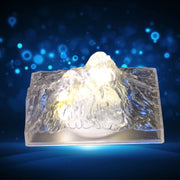 A clear plastic Iceberg Night Light illuminating a dark room, showcasing its unique design.