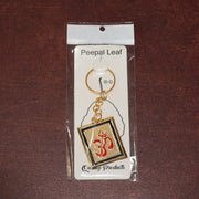 Om Trishul symbol keychain resting on surface, showcasing design and metal material