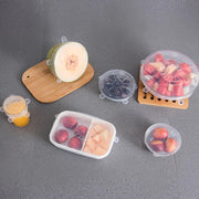 Clear silicone stretch lids covering plates with leftovers.