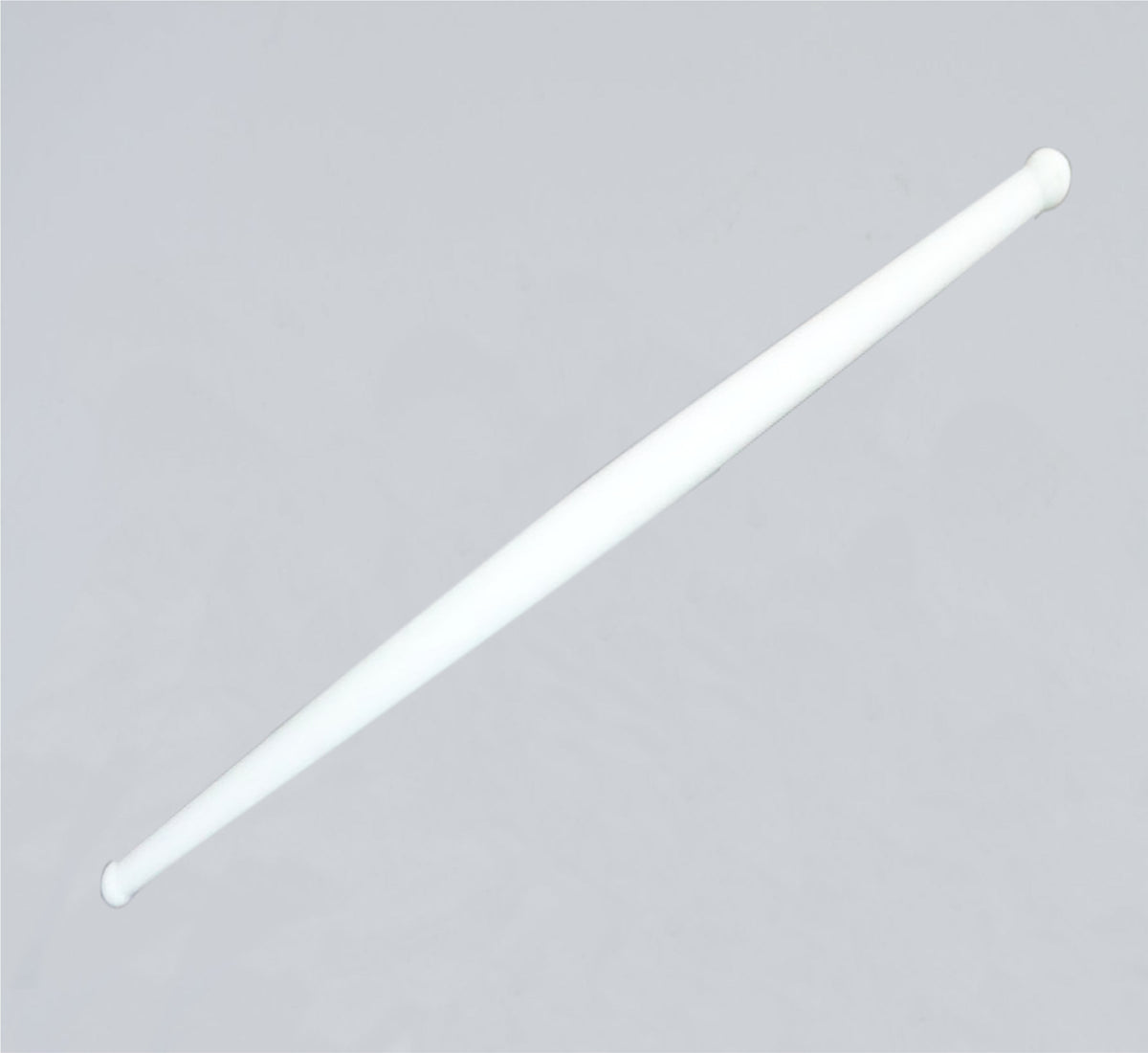 Clean white plastic rolling pin resting on a modern kitchen countertop, ready for use.