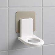 Close-up of a white wall-mounted shampoo holder with a bottle.