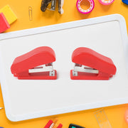 Hand using a FiloDesk mini stapler to bind papers, highlighting its ease of use.