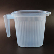 Close-up of the Transparent Bath Mug's sturdy handle and square shape.