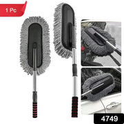 Person using the retractable car duster to clean a car's exterior.