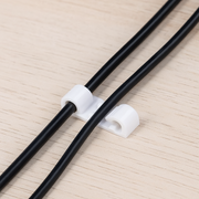 Multiple cable clips securing various power cords to maintain an organised workspace.