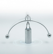 The Newton Cradle's metal balls in mid-swing, illustrating kinetic energy transfer.