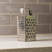 Close-up of multi-sided stainless steel grater and slicer tool