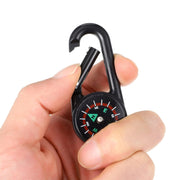 A hand attaching the mini compass with clip to a belt loop, emphasizing its convenient attachment.
