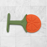 Baby's hand grasping a silicone fruit teether toy, showing ergonomic design.