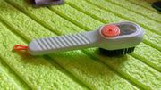 Angled view of the scrubbing brush with dispenser, highlighting its design.