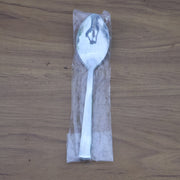 Stacked stainless steel dining spoons placed in a home kitchen setting