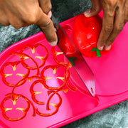 Side view of the Quickslice plastic chopping board with a full tray.