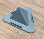 Grey pyramid mobile phone stand placed on office desk