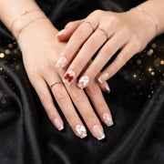 Close-up of glitter 3D floral press-on nails highlighting intricate petal and crystal embellishments.