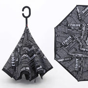 A reverse umbrella with a black and white newspaper print, shown both closed and partially open.