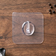 Self-adhesive clear wall hook in use for organizing small items
