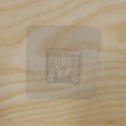 Pack of multiple transparent self-adhesive wall hooks.
