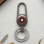 Durable metal key holder with dual rings and locking clip attached to a backpack
