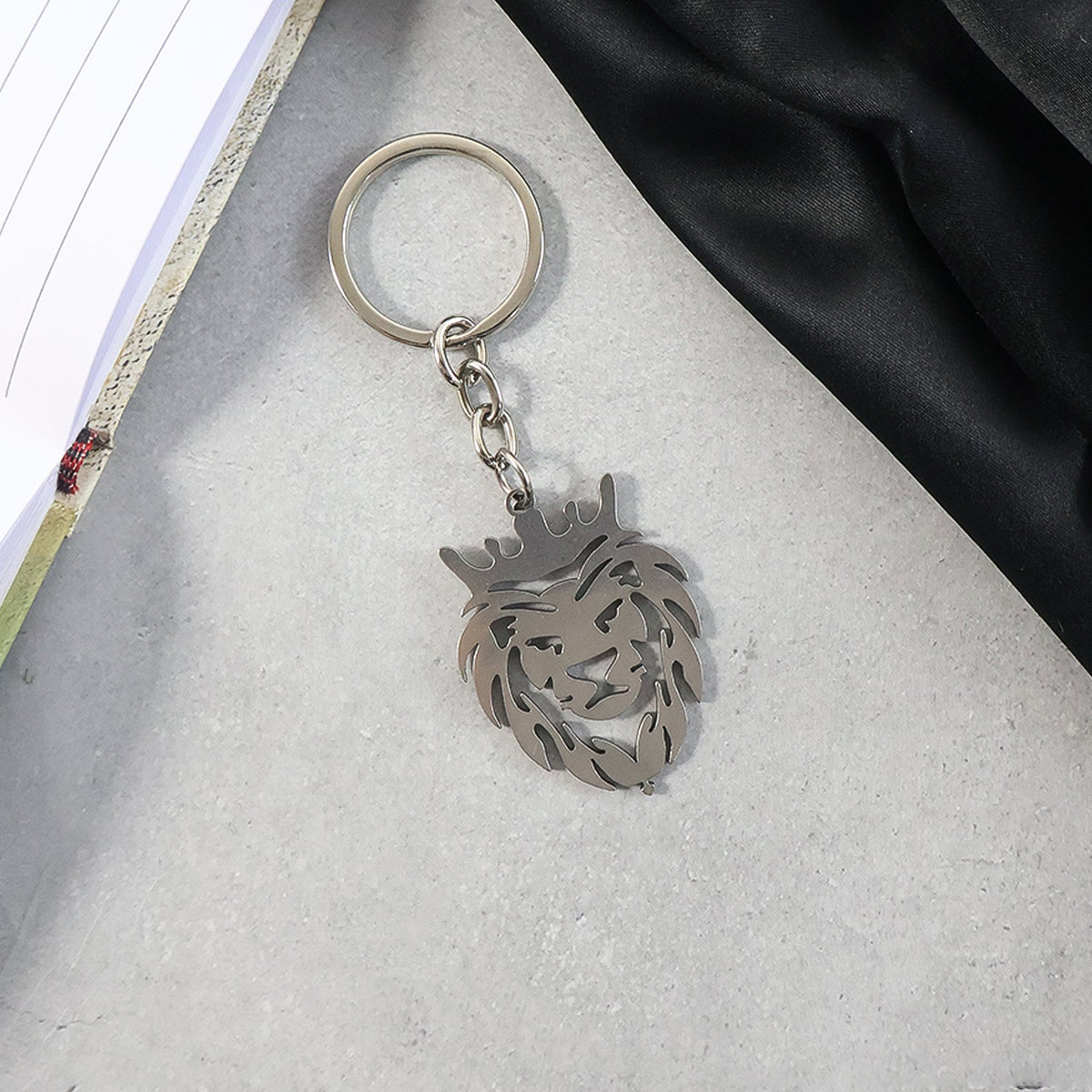 Crowned lion head keychain held in hand showing size and elegant design